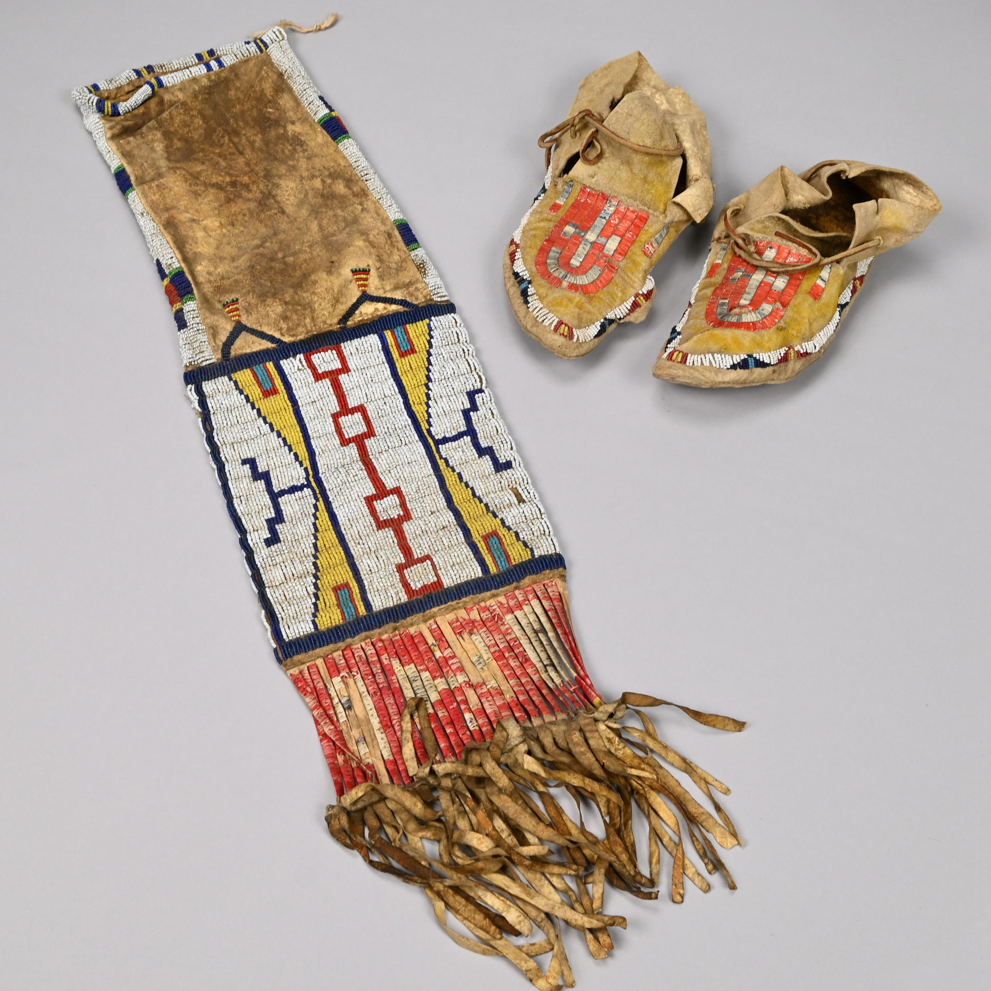 American Plains Indian Quill, Beadwork and Deer Hide Pipe Bag and Pair of Moccasins, Probably Arapaho, Lakota or Sioux, Late Nineteenth Century